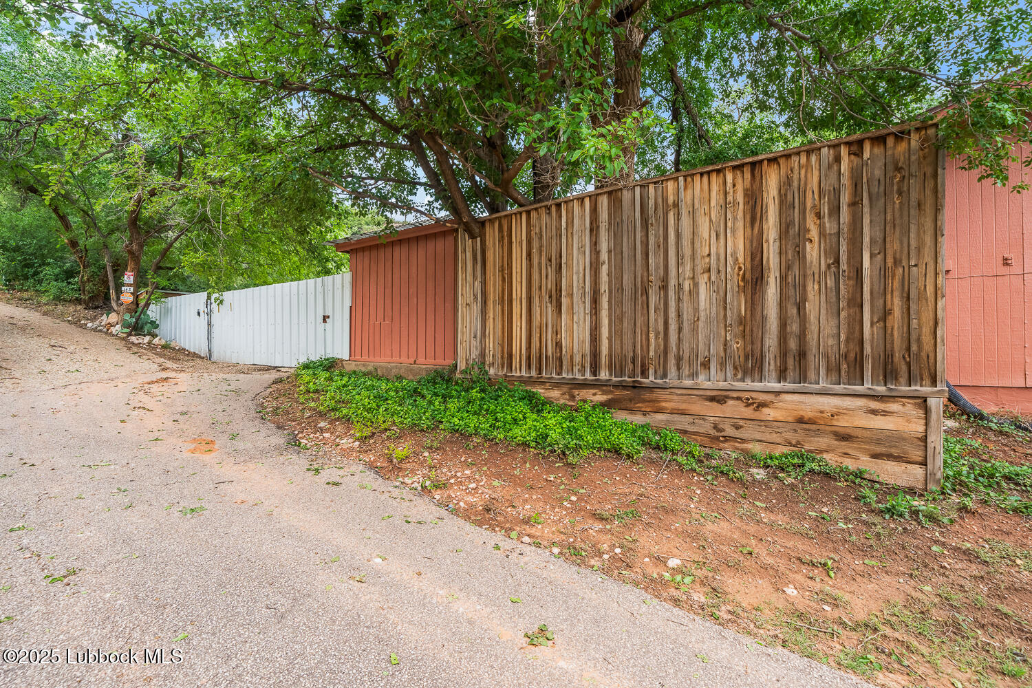 146 Pony Express Trail Buffalo Springs, TX 79404 - Photo 30 of 48 a backyard of a house with plants and trees with wooden fence