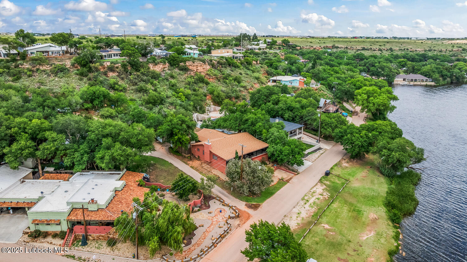 146 Pony Express Trail Buffalo Springs, TX 79404 - Photo 32 of 48 an aerial view of a house with a garden and lake view