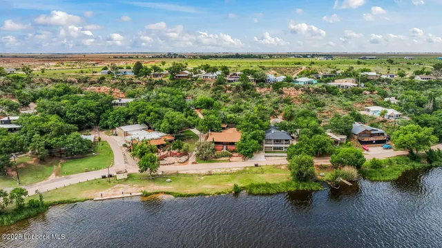an aerial view of a house with a garden and lake view