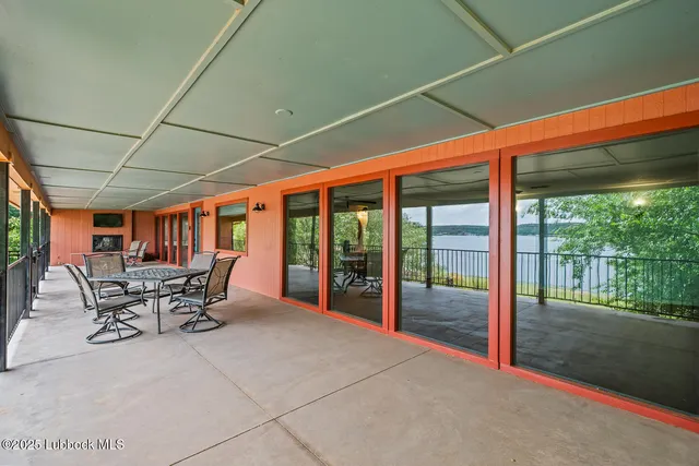 a view of a patio with table and chairs next to a yard