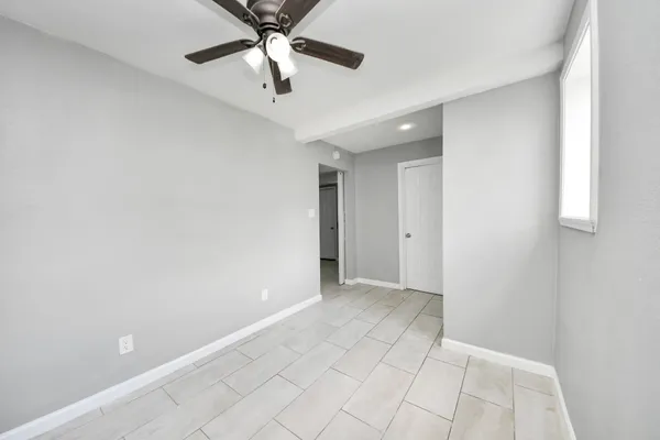 an empty room with fan and windows