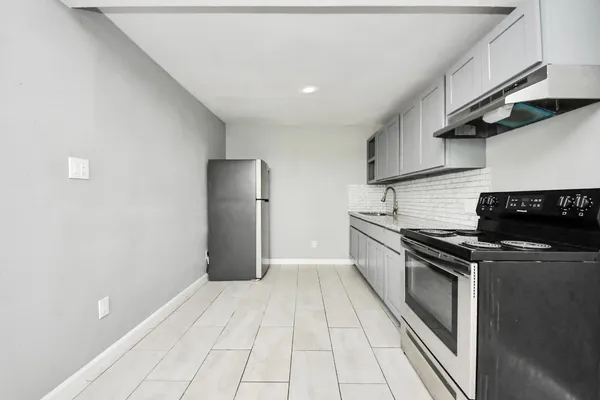 a kitchen with granite countertop a stove and a refrigerator