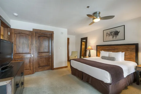 a bedroom with a large bed and a flat tv screen on a dresser