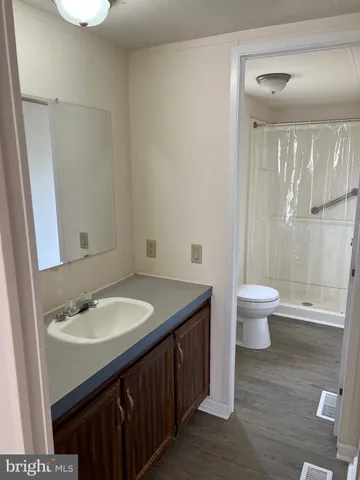 a bathroom with a granite countertop sink a toilet and a mirror