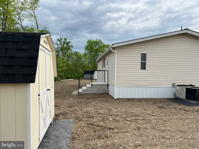 a view of a house with backyard and trees
