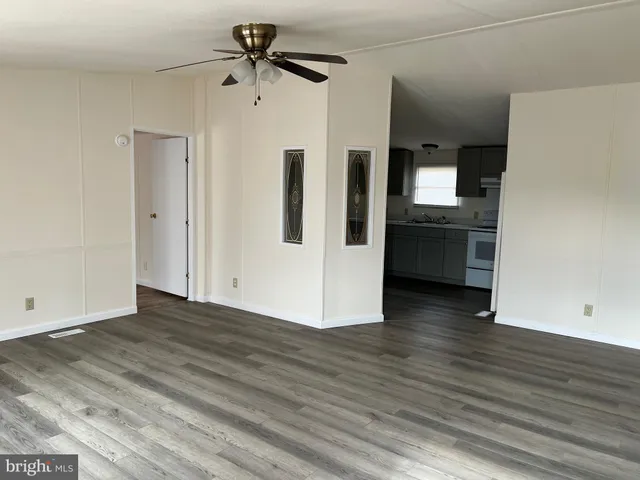 a view of a kitchen with wooden floor and a refrigerator