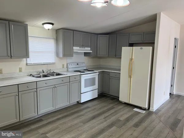 a kitchen with white cabinets and white appliances