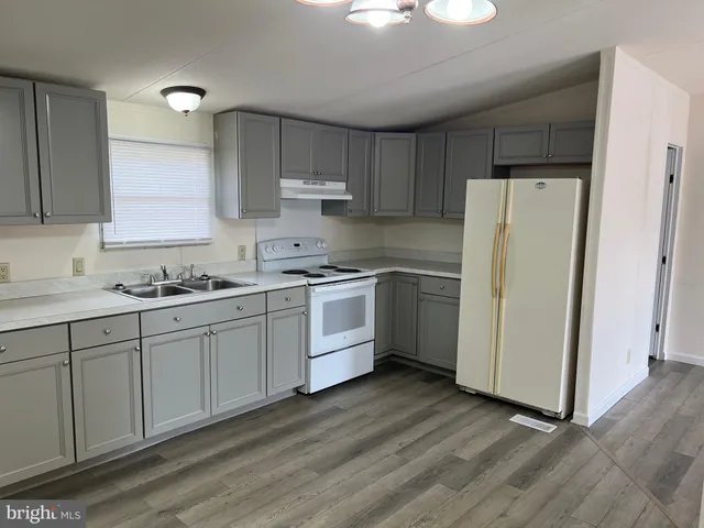a kitchen with white cabinets and white appliances