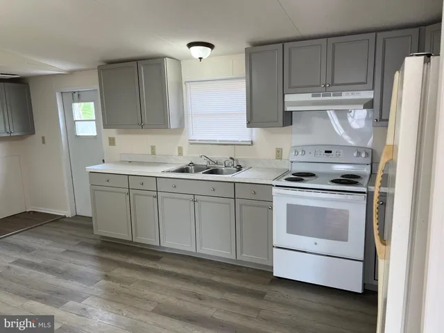 a kitchen with stainless steel appliances a stove a sink and a refrigerator