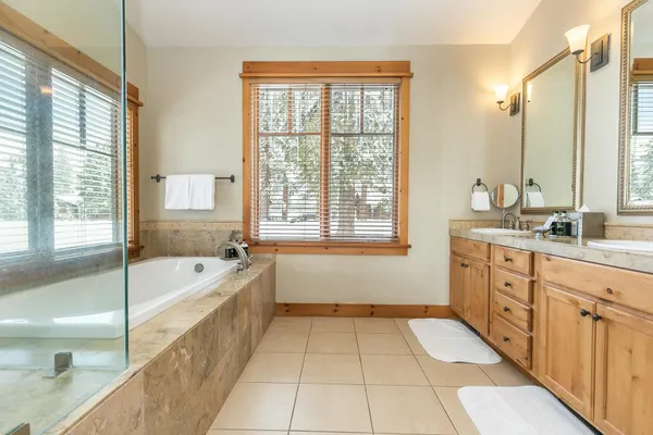 a spacious bathroom with a tub sink shower and mirror