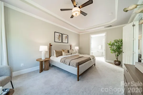 a spacious bedroom with a bed and a potted plant