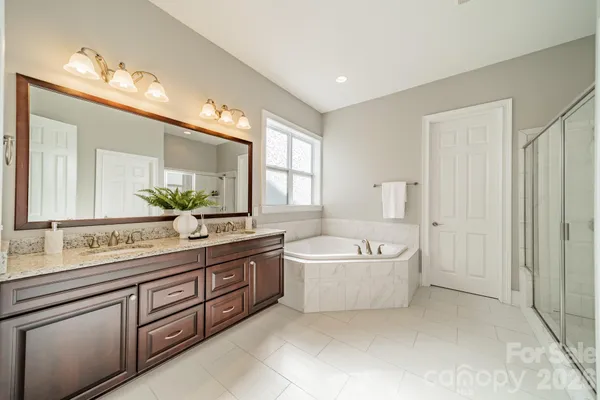 a bathroom with a tub a sink and mirror