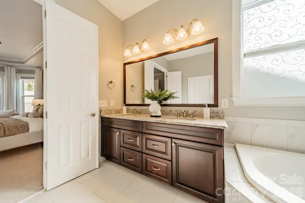 a en suite bathroom with a granite countertop sink and a mirror