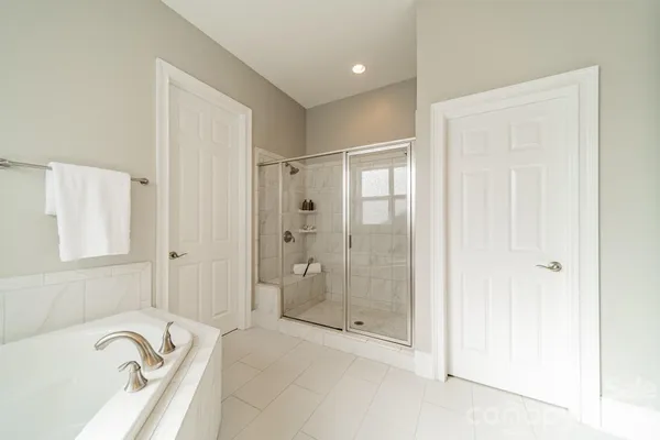 a bathroom with a tub shower sink and mirror
