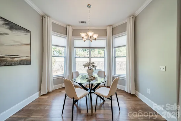 a dining room with furniture large windows and a chandelier