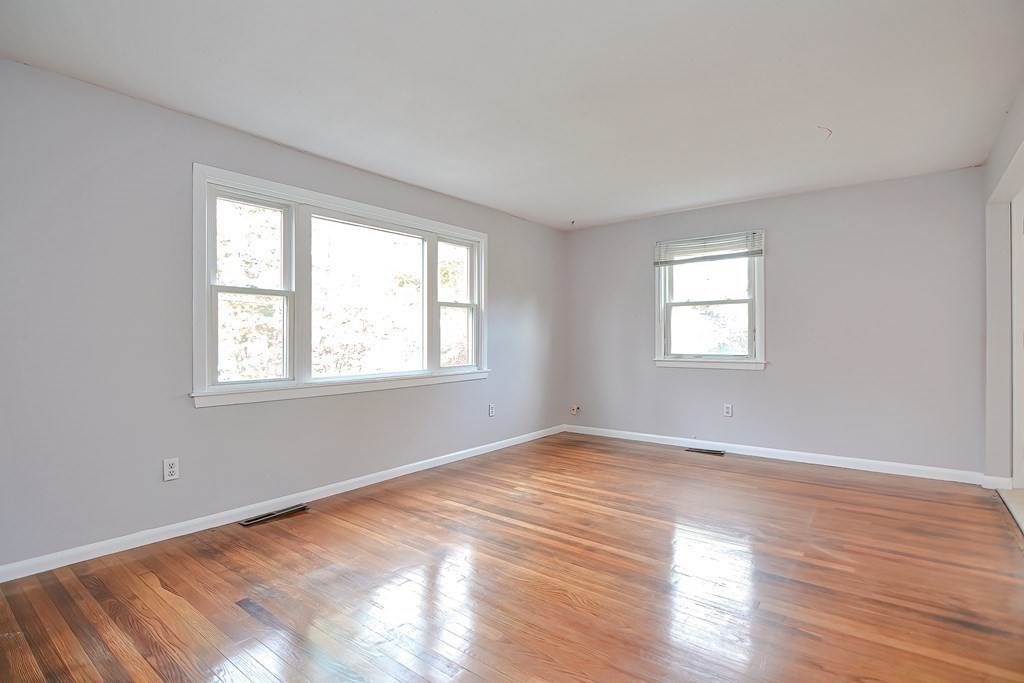 151 Baldwin Road, Unit 151 Billerica, MA 01821 - Photo 5 of 22 a view of an empty room with wooden floor and a window