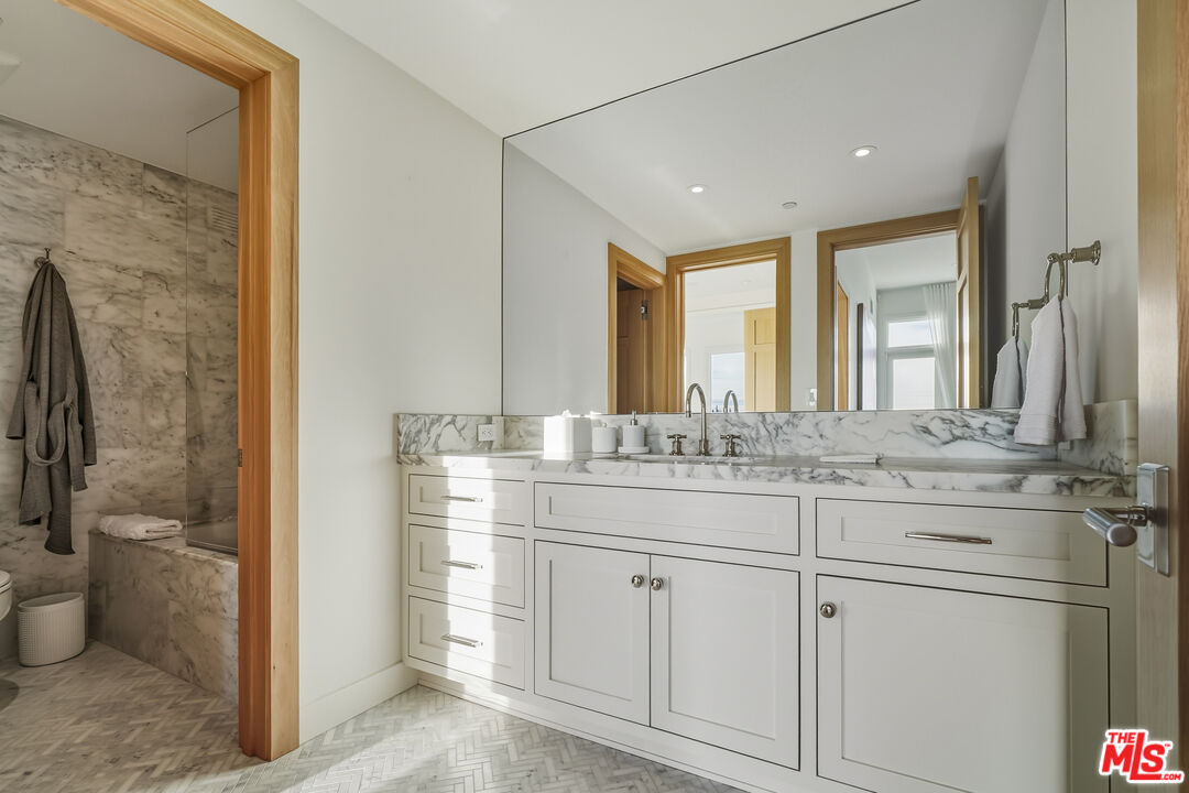 3140 Sweetwater Mesa Road Malibu, CA 90265 - Photo 25 of 71 a bathroom with a granite countertop sink a toilet and a mirror