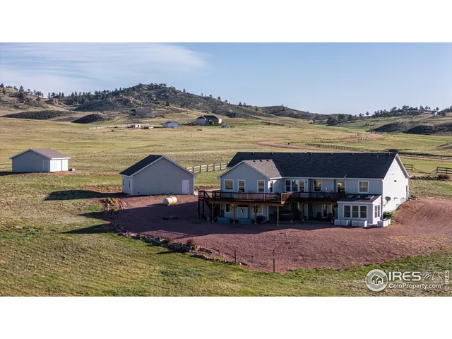 a aerial view of a house with big yard and large mountain view