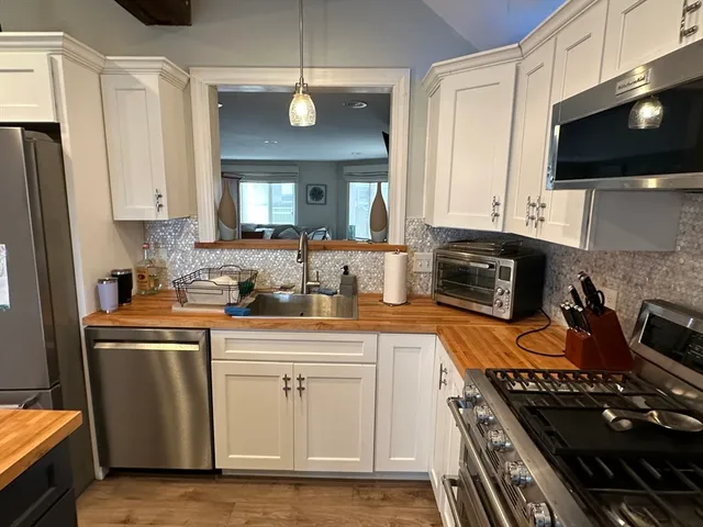 a kitchen with stainless steel appliances kitchen island granite countertop a refrigerator stove and sink