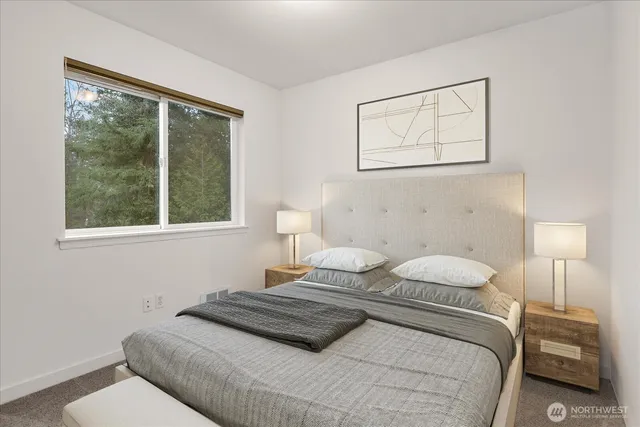 a view of a backyard with large trees and wooden fence