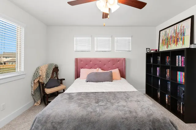 a bedroom with a bed and a flat tv screen on dresser