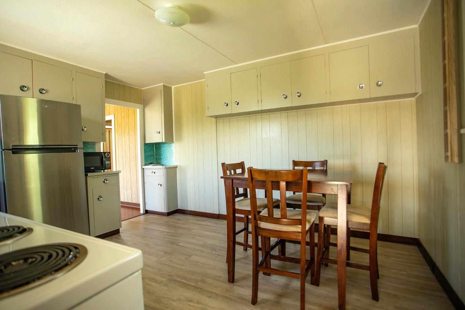 741 Haiku Road Haiku, HI 96708 - Photo 11 of 26 a kitchen with a table chairs refrigerator and cabinets