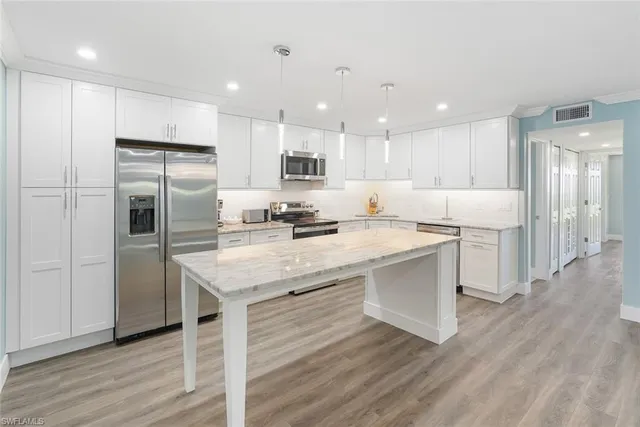 a kitchen with a refrigerator a sink and a microwave