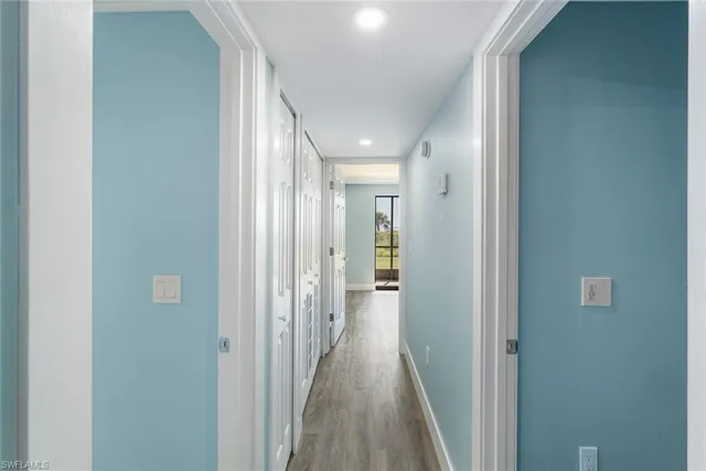 a view of a hallway with wooden floor