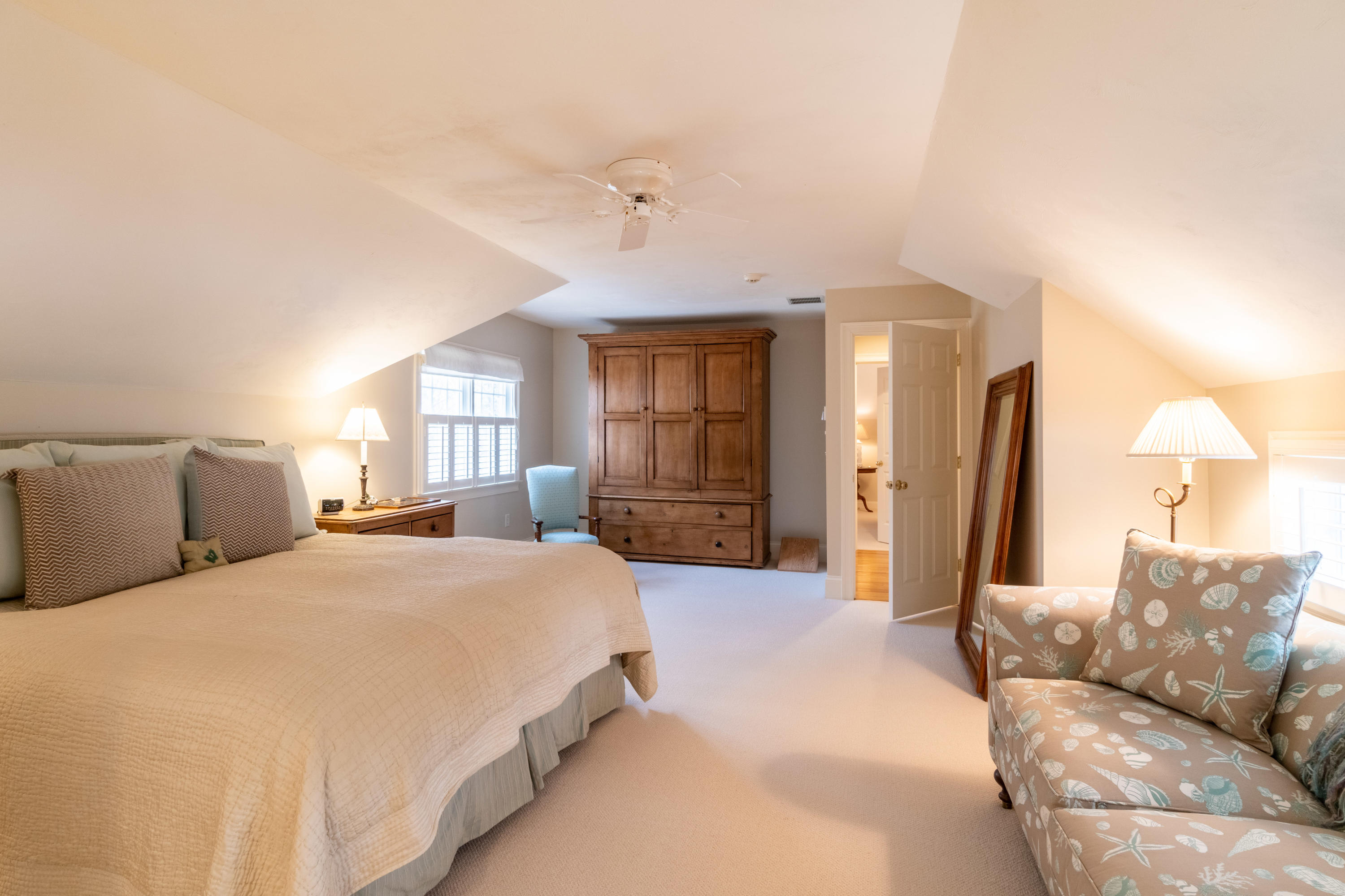 150 Training Field Road Chatham, MA 02633 - Photo 25 of 42 a spacious bedroom with a bed a couch and large mirror