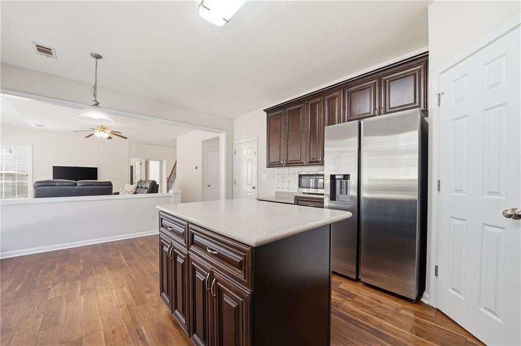 310 Hammersmith Drive Suwanee, GA 30024 - Photo 11 of 55 a kitchen with kitchen island a counter top space a sink stainless steel appliances and cabinets