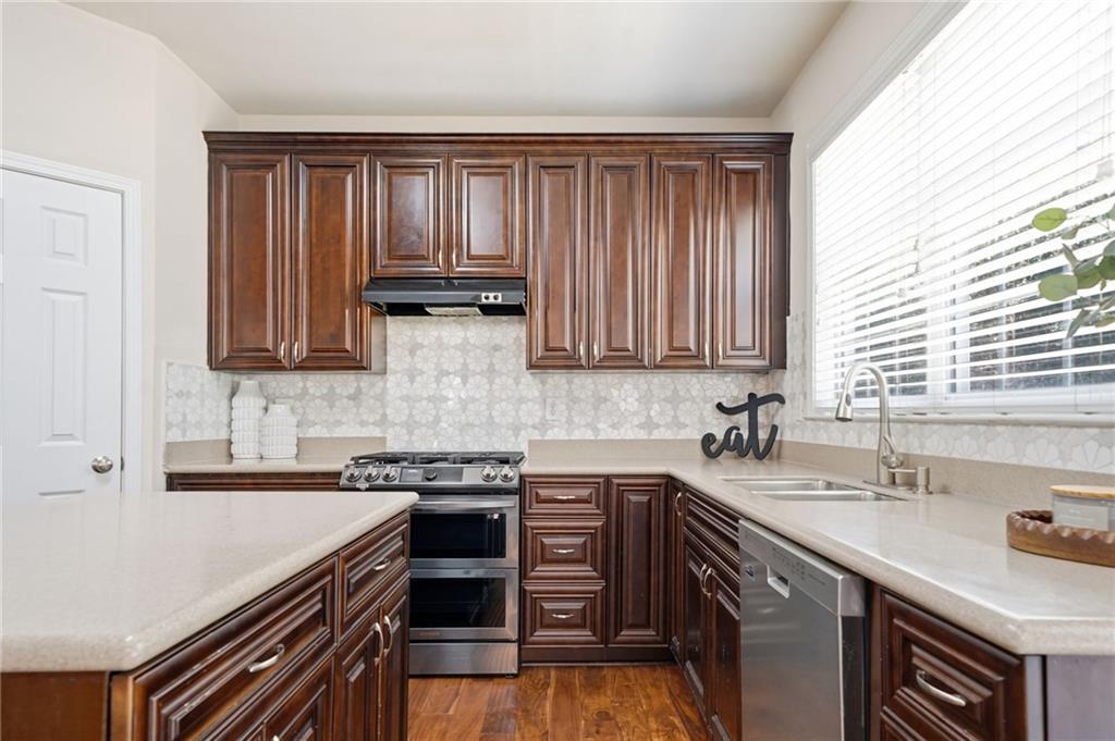 310 Hammersmith Drive Suwanee, GA 30024 - Photo 12 of 55 a kitchen with stainless steel appliances granite countertop a sink stove and cabinets
