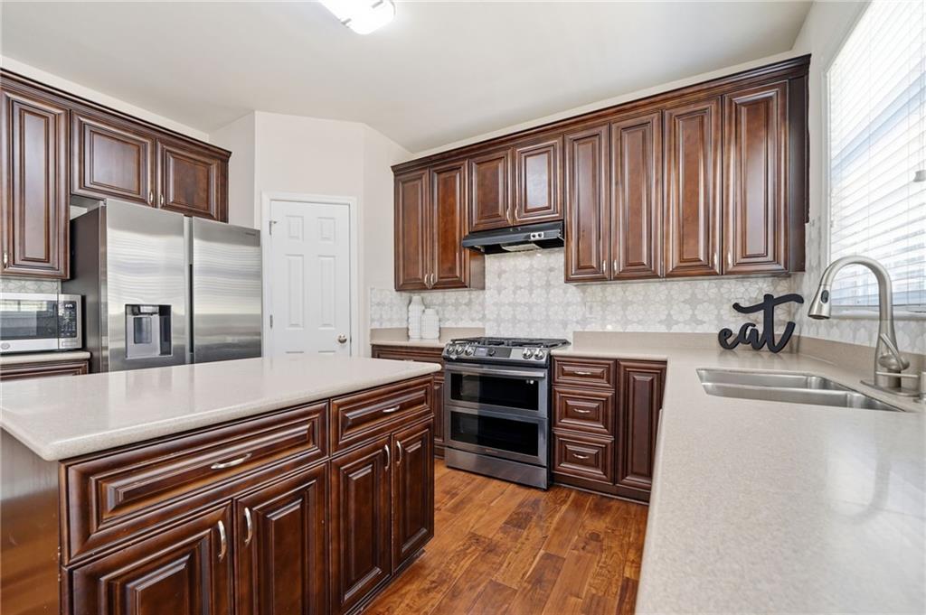 310 Hammersmith Drive Suwanee, GA 30024 - Photo 13 of 55 a kitchen with stainless steel appliances granite countertop a stove a sink and a microwave