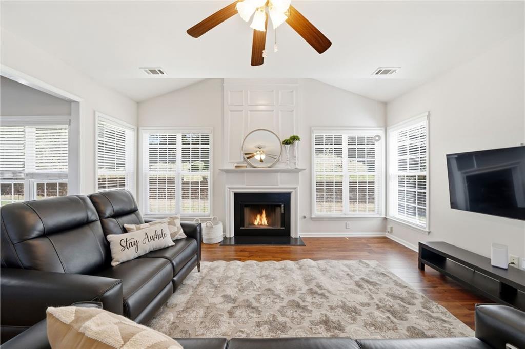 310 Hammersmith Drive Suwanee, GA 30024 - Photo 18 of 55 a living room with furniture a flat screen tv and a fireplace