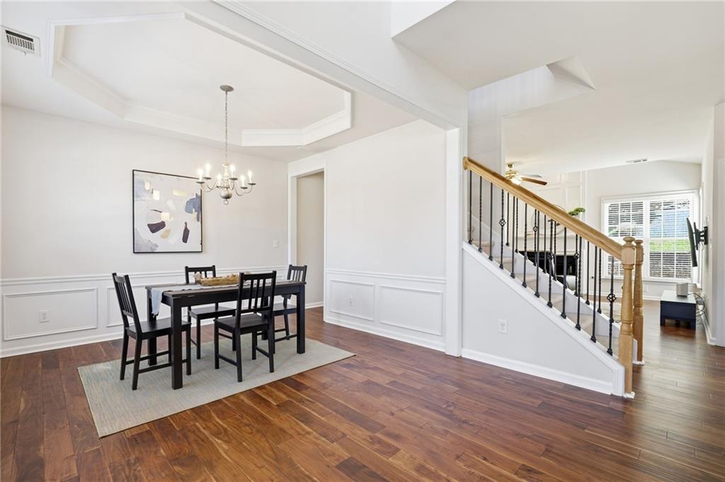 310 Hammersmith Drive Suwanee, GA 30024 - Photo 25 of 55 a view of a dining room and livingroom with furniture wooden floor a chandelier