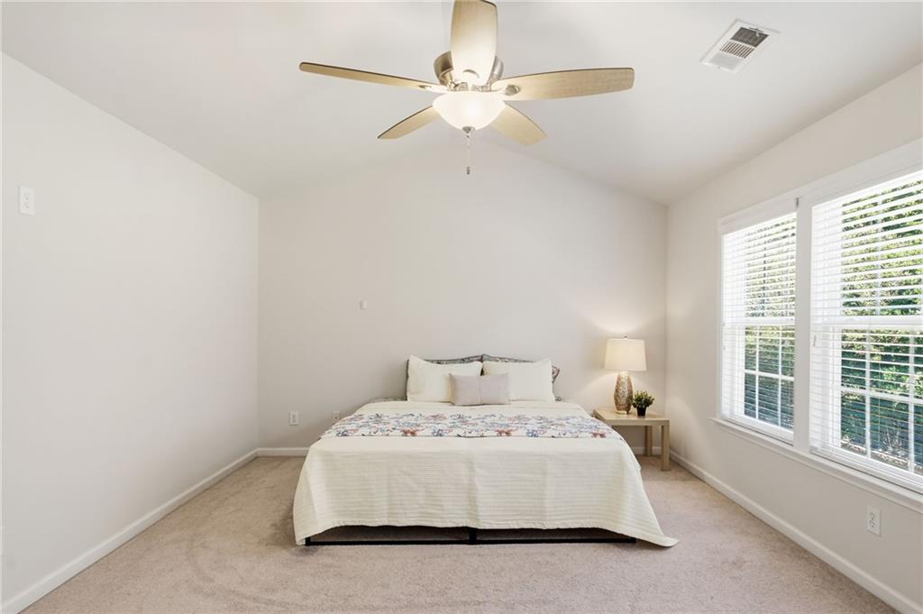 310 Hammersmith Drive Suwanee, GA 30024 - Photo 29 of 55 a bedroom with a large bed and a ceiling fan
