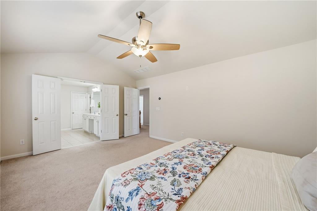 310 Hammersmith Drive Suwanee, GA 30024 - Photo 31 of 55 a bedroom with a large bed and a chandelier fan