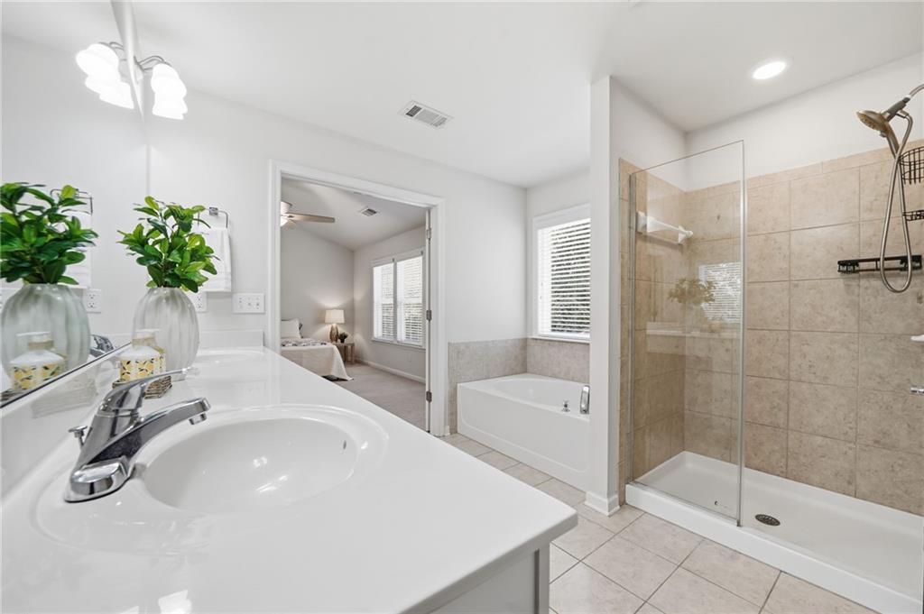 310 Hammersmith Drive Suwanee, GA 30024 - Photo 35 of 55 a bathroom with a sink a faucet a mirror and a shower