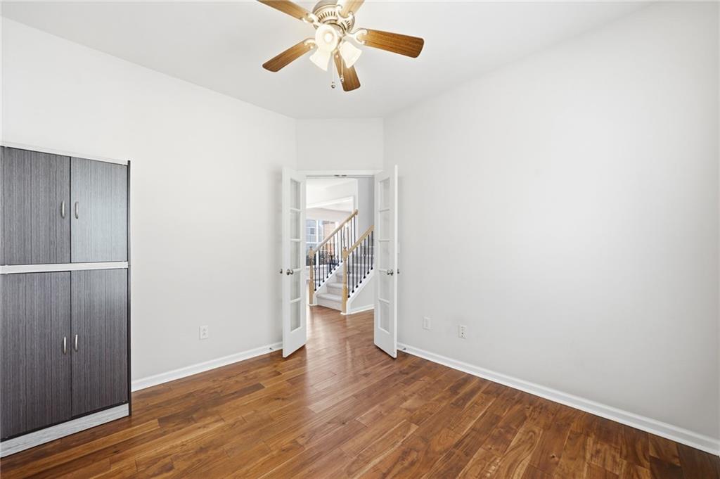 310 Hammersmith Drive Suwanee, GA 30024 - Photo 6 of 55 a view of an empty room with wooden floor and a ceiling fan