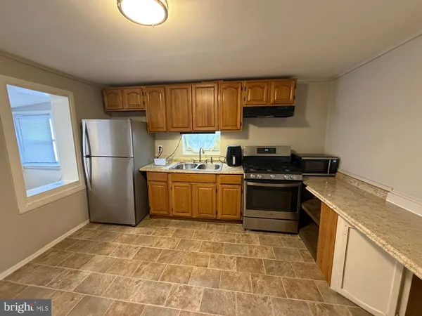 a kitchen with a stove a refrigerator and a white cabinets