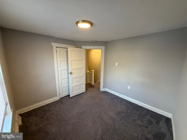 an empty room with closet and windows