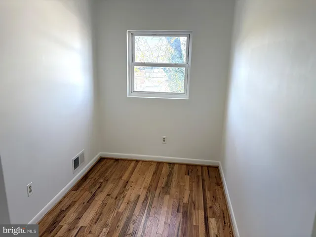 a view of a room with wooden floor and window
