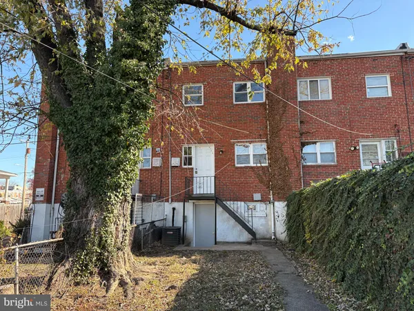 a view of a house with a yard and large tree