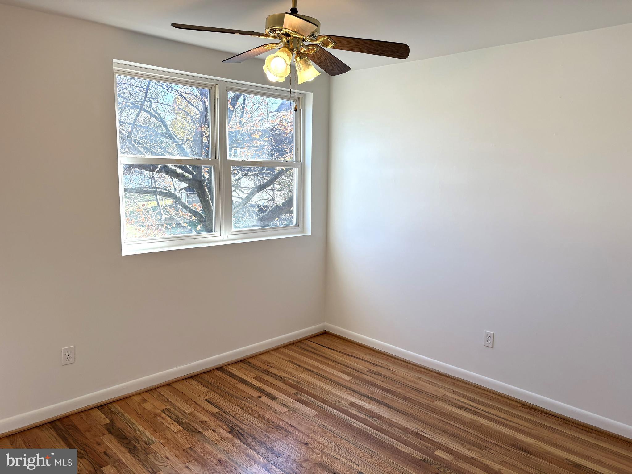 3820 2nd Street Baltimore, MD 21225 - Photo 10 of 23 an empty room with wooden floor fan and windows