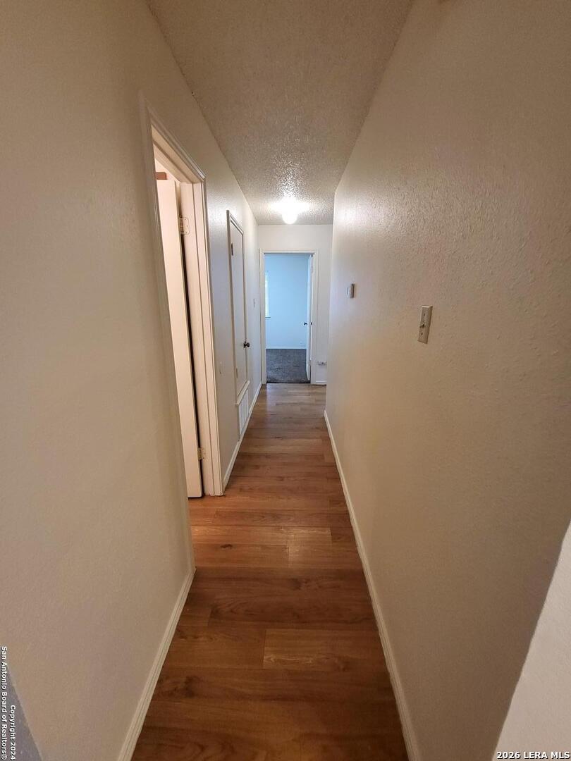 12204 Ridge Crown Street San Antonio, TX 78247 - Photo 5 of 10 a view of a hallway with wooden floor