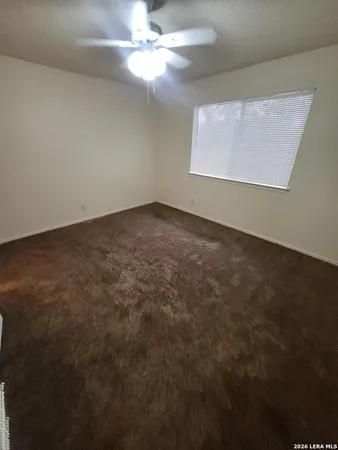 en empty room with windows and fan