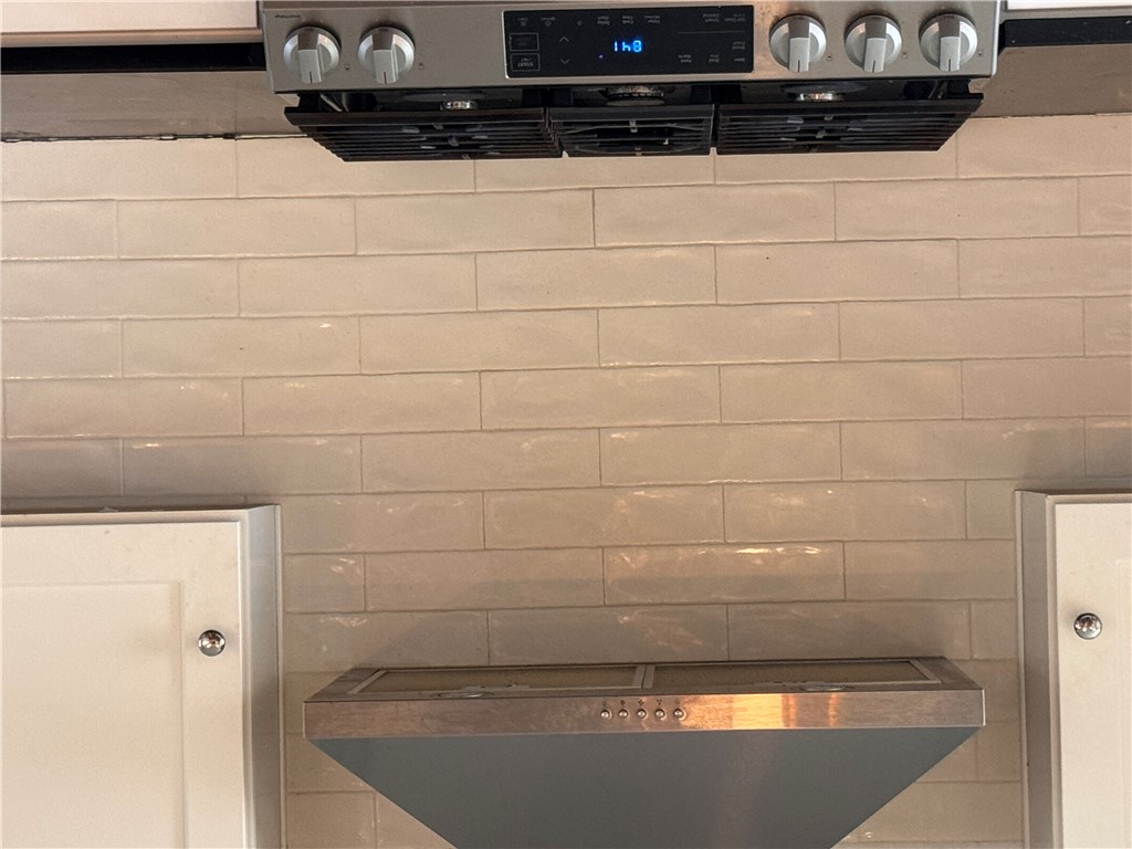 2211 East River Street Anderson, SC 29621 - Photo 17 of 40 This kitchen showcases a modern range hood and a sleek built-in gas range, perfect for culinary endeavors.