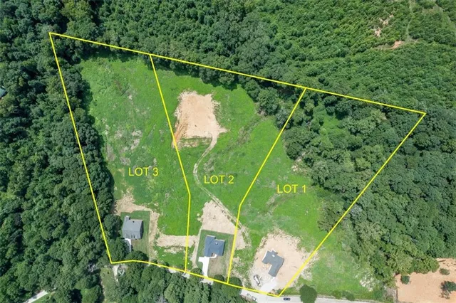 a green field with lots of trees in the background