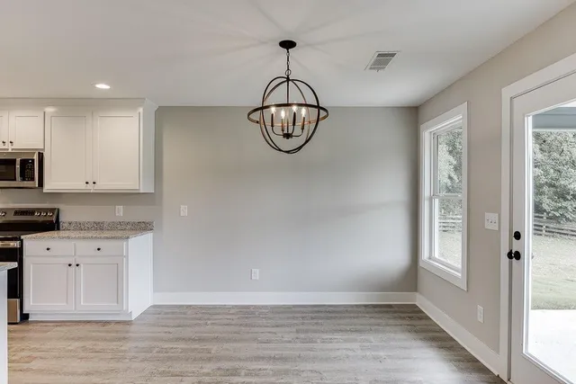 a view of a kitchen with wooden floor and window
