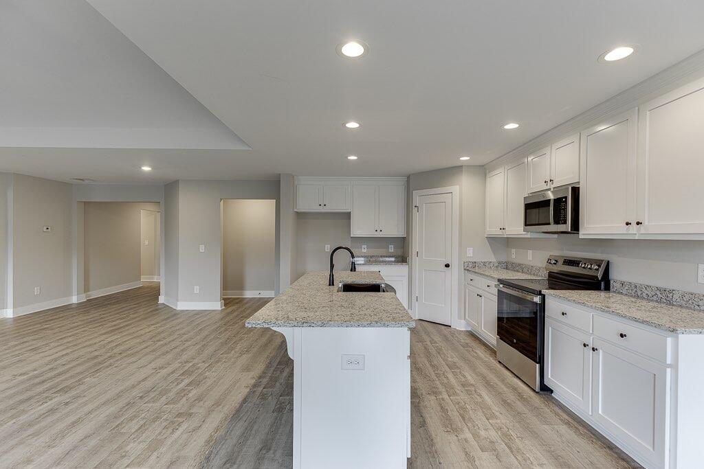 295 Anderson Thomas Road Martin, GA 30557 - Photo 17 of 44 a kitchen with granite countertop a sink stainless steel appliances and white cabinets