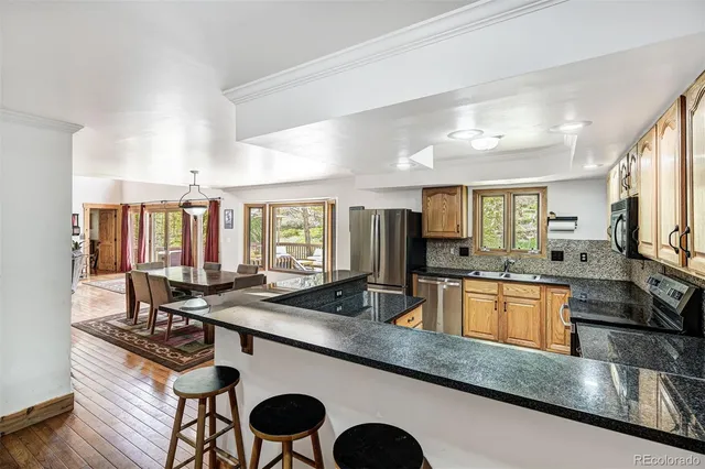 a kitchen with stainless steel appliances granite countertop a sink stove and cabinets